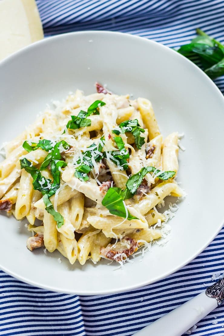 Creamy chicken pasta in a bowl on a striped cloth