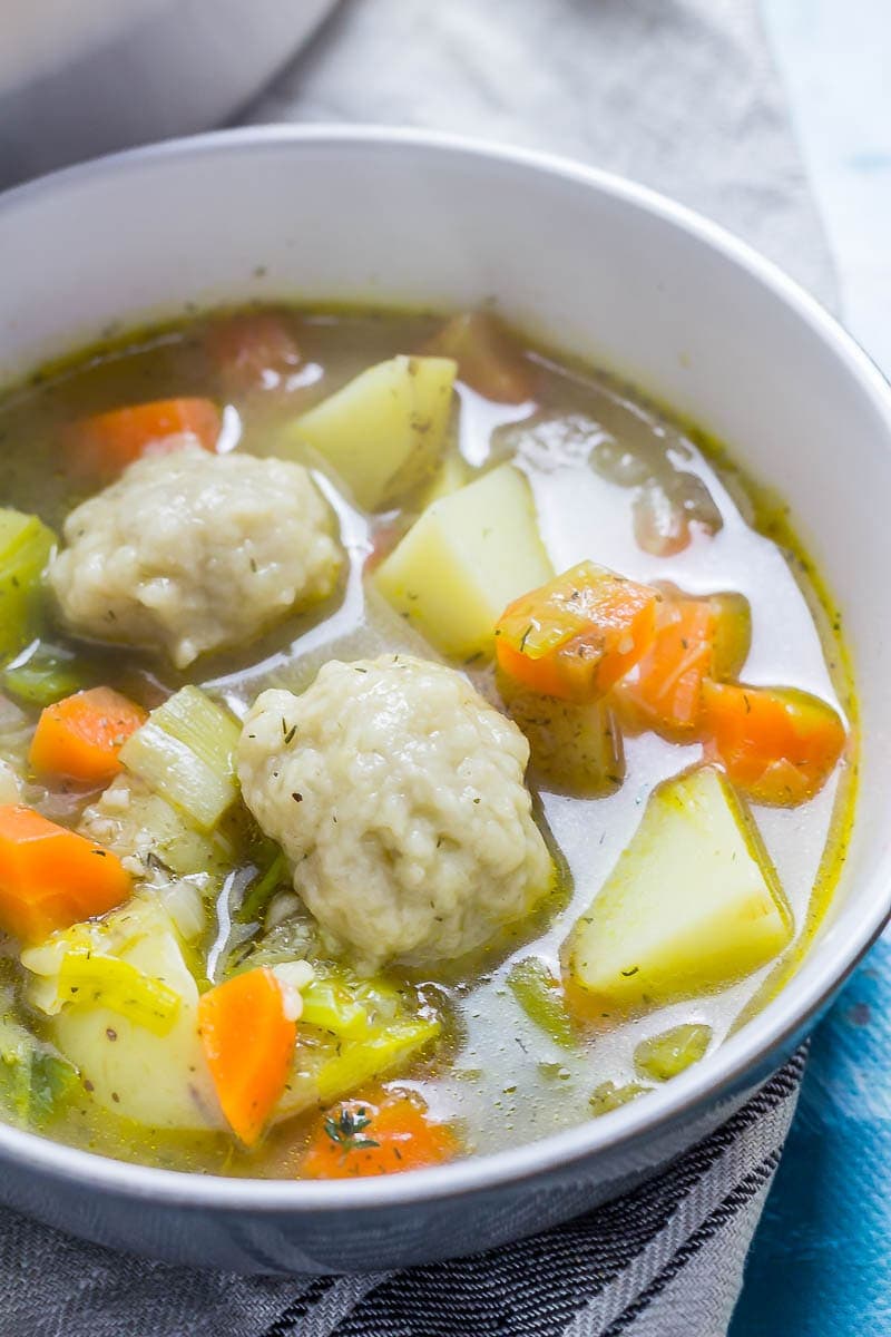 Bowl of vegetable soup with dumplings on a towel