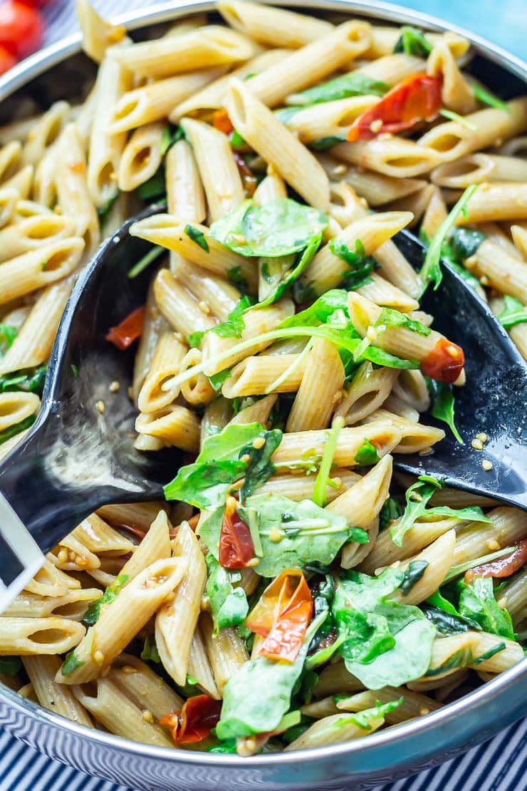 Close up of pasta with salad servers