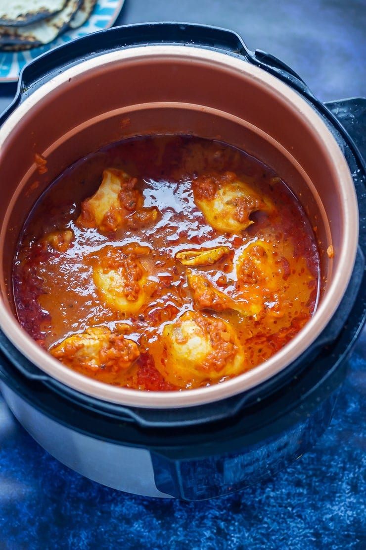 Chipotle chicken tacos in the pressure cooker with a blue background