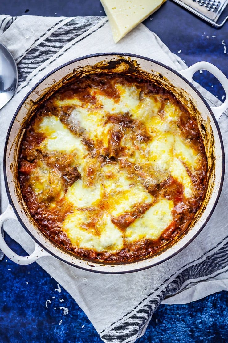 Overhead shot of One Pot Lasagne on a towel with parmesan and a grater