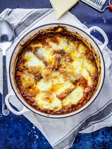 Overhead shot of one pot lasagne on a blue background