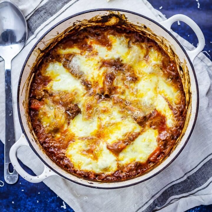 Overhead shot of one pot lasagne on a blue background