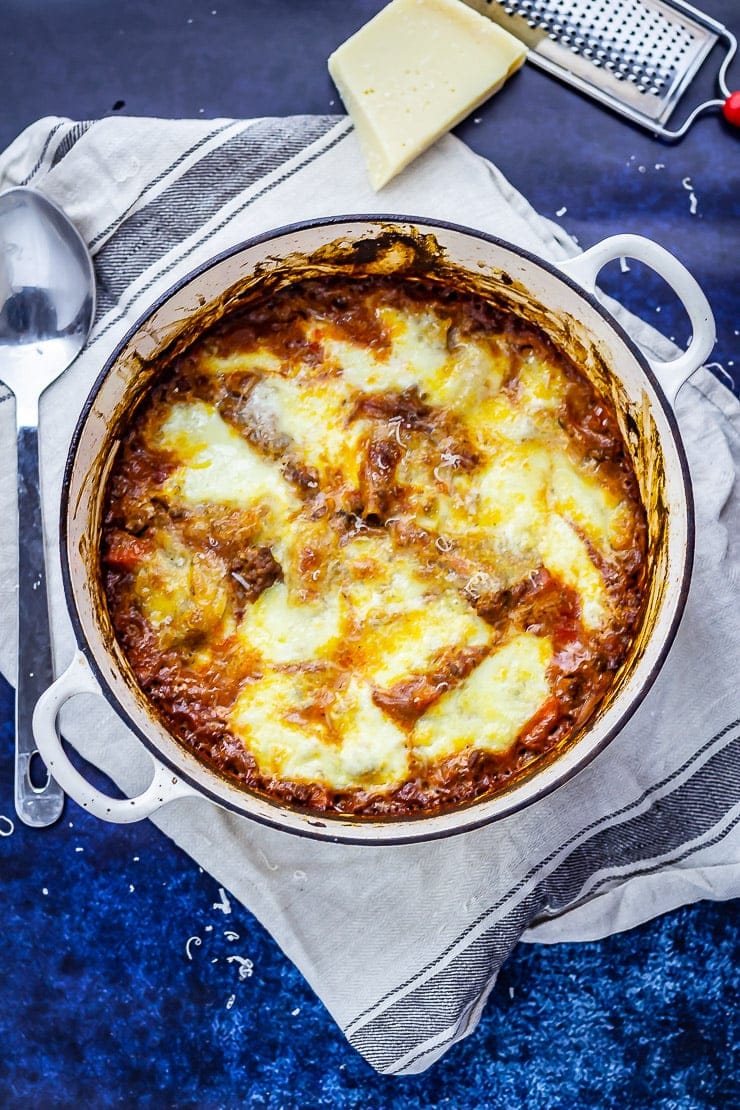 Overhead shot of one pot lasagne on a blue background