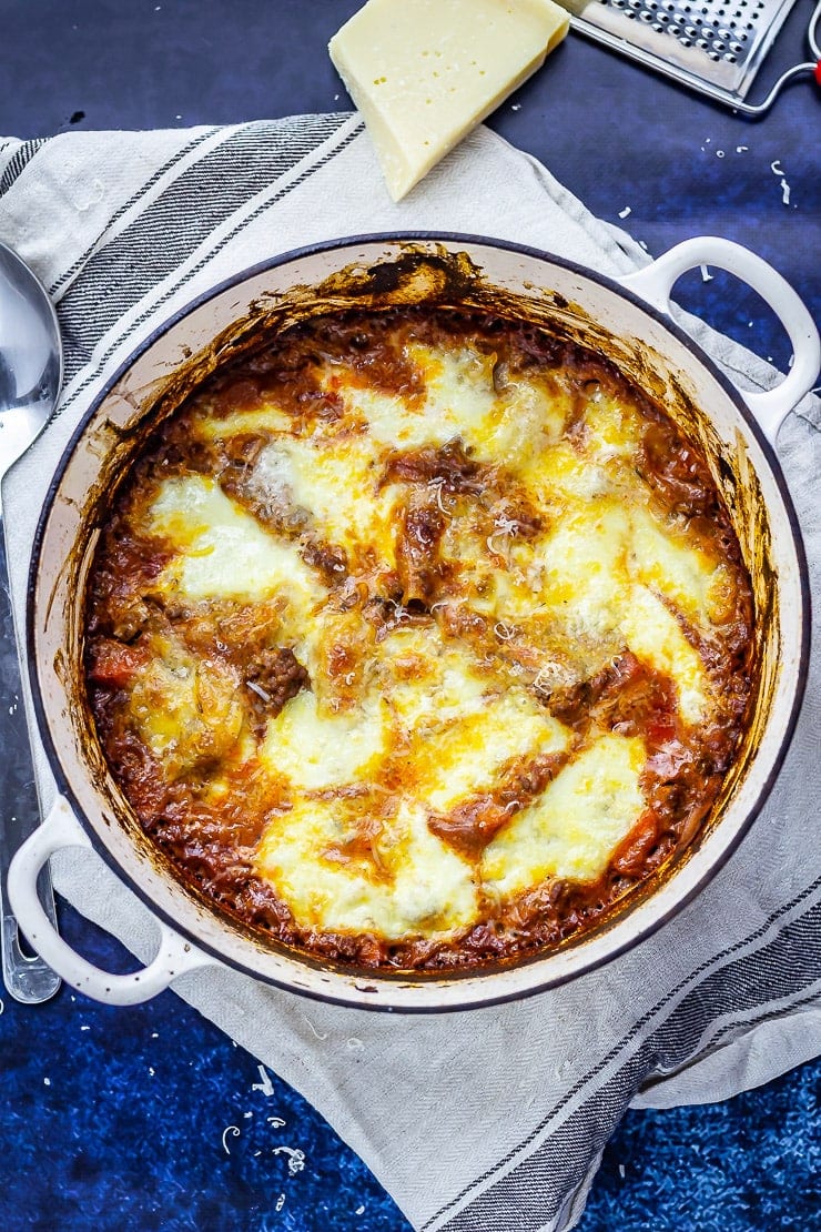 Overhead shot of one pot lasagne on a towel with a dark blue background