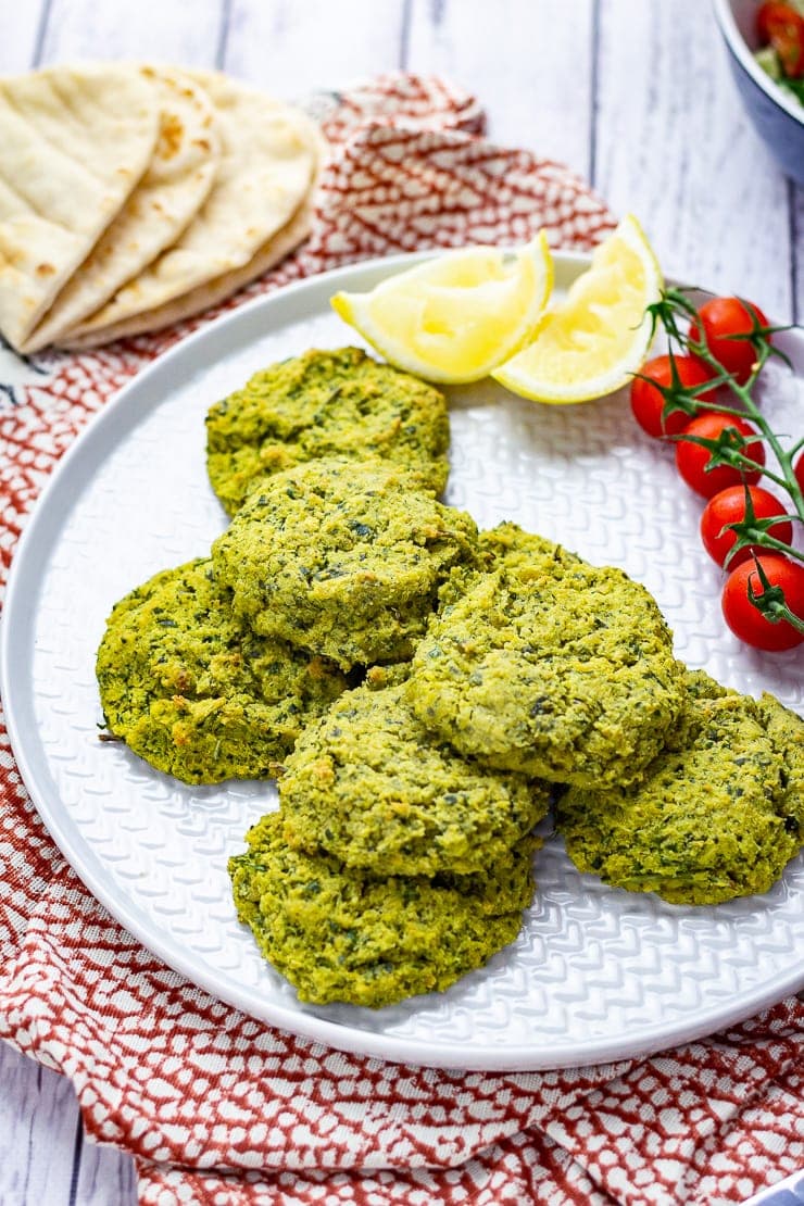 Platter of baked falafel with cherry tomatoes, lemon slices and flatbreads