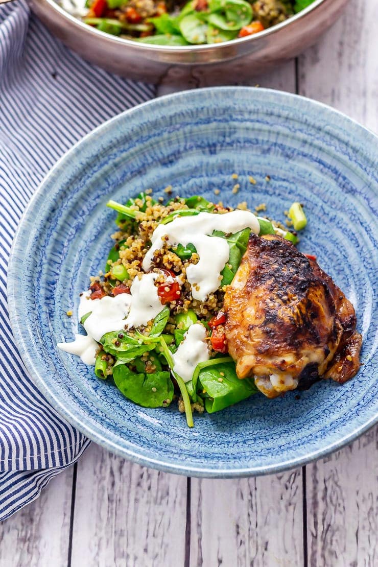 Chipotle chicken salad with quinoa in a blue bowl on a white wooden background