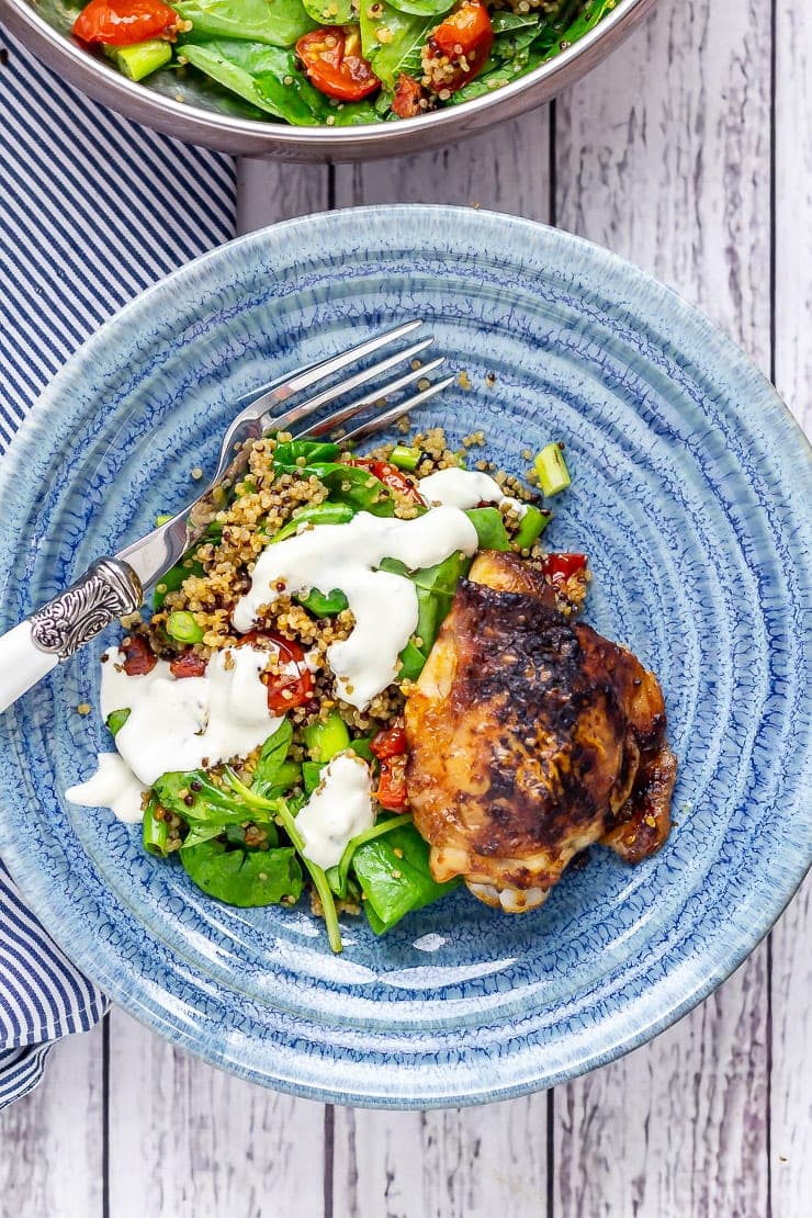 Chipotle chicken salad with quinoa in a blue bowl on a white wooden background