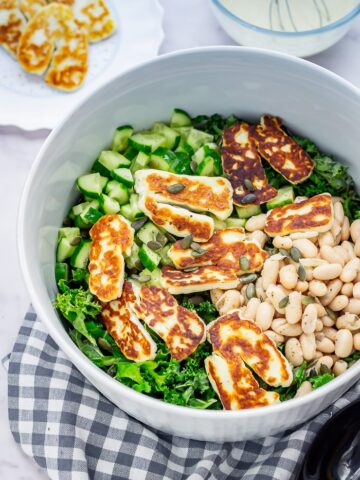 Halloumi salad in a bowl on a checked cloth on a marble background