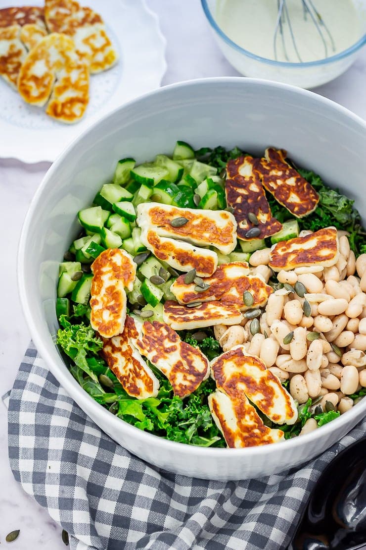 Halloumi salad in a bowl on a checked cloth on a marble background