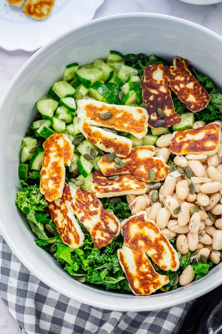 Overhead shot of halloumi salad with kale on a checked cloth