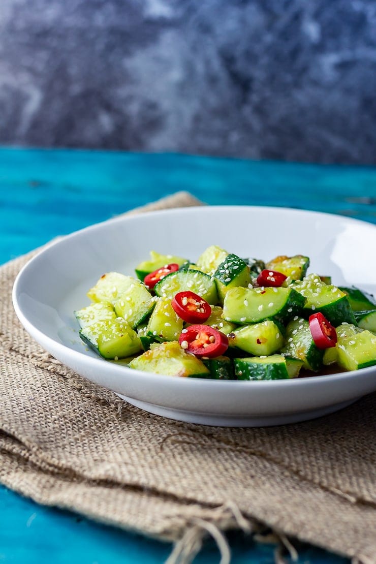 Side shot of sesame cucumber salad on a hessian background