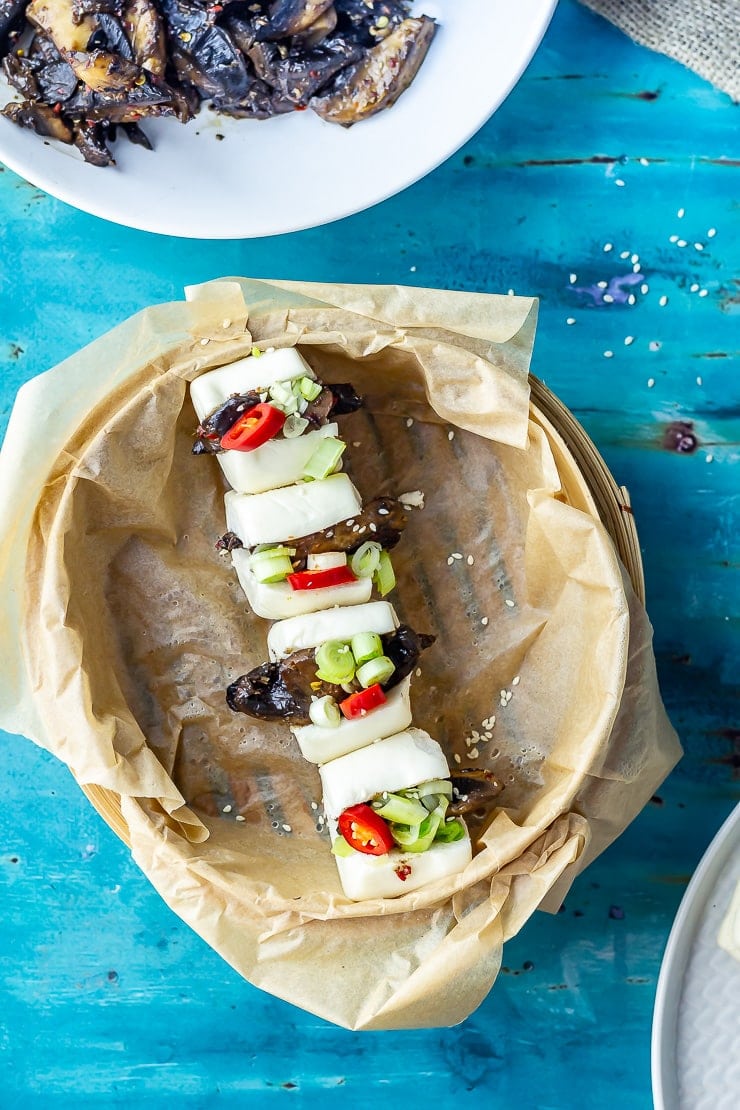 Overhead shot of mushroom bao in a steamer on a blue background