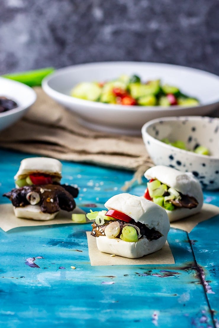 Photo of mushroom bao with cucumber salad in the background