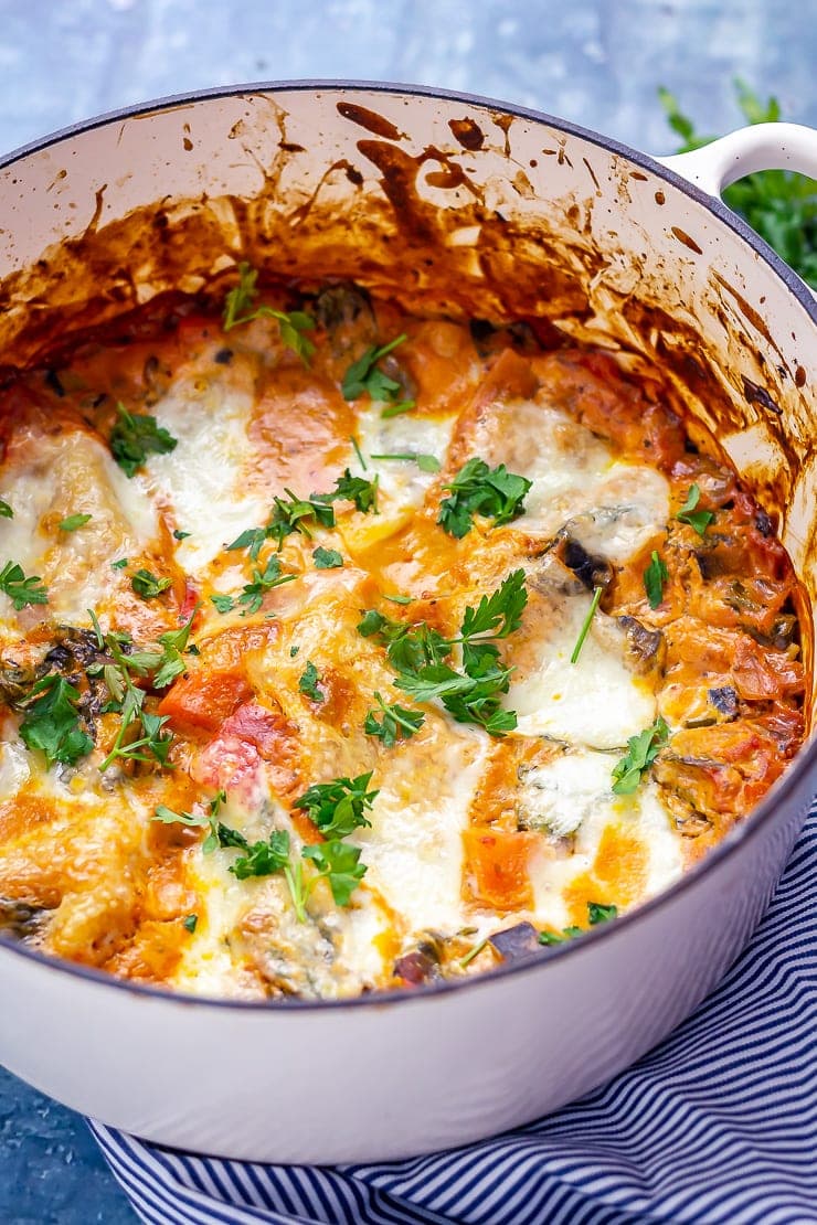 One pot vegetarian lasagne in a white pot on a blue background