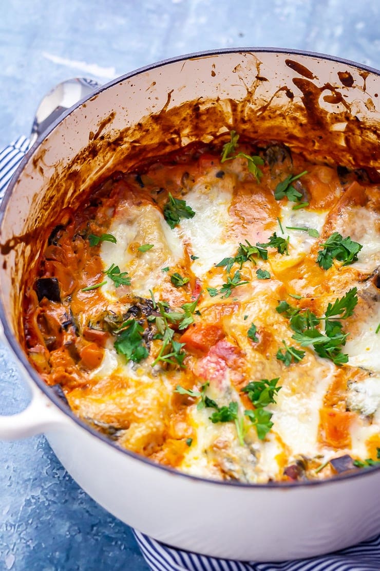 One pot vegetarian lasagne in a white pot on a blue background