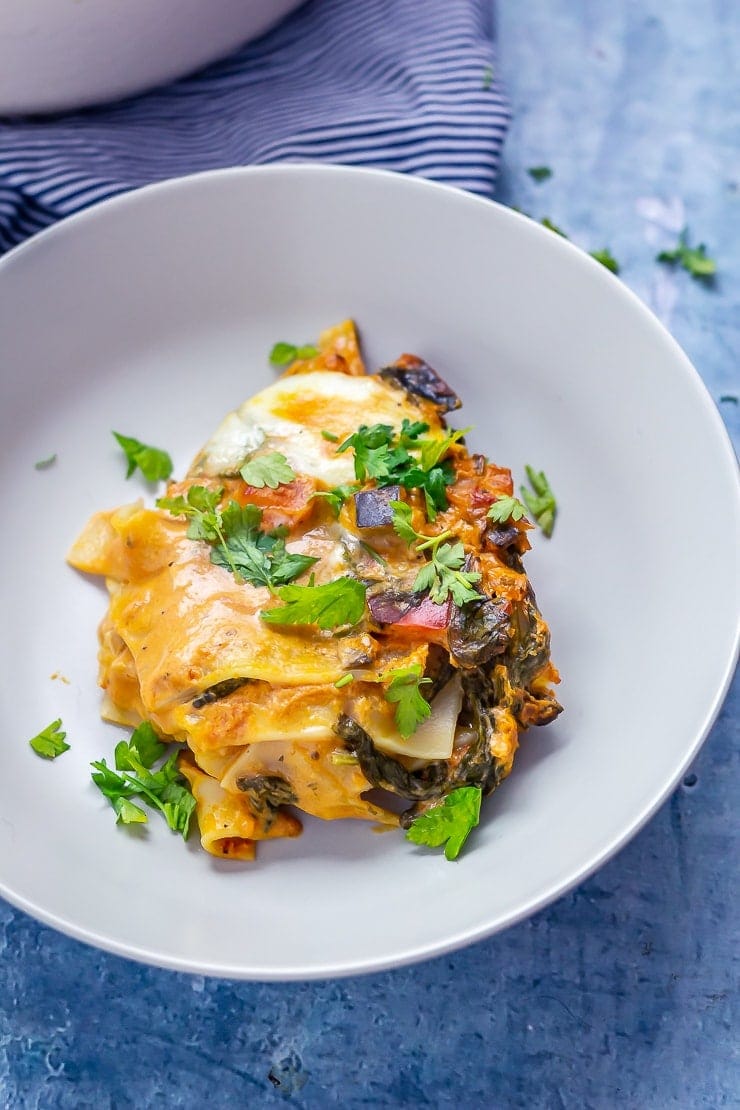 Portion of one pot vegetarian lasagne on a blue background