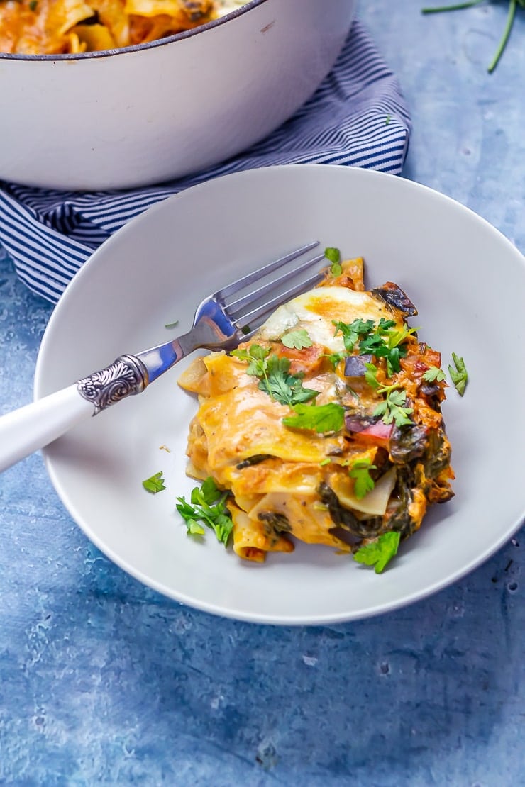 Portion of one pot vegetarian lasagne on a blue background