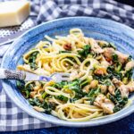 Bowl of pressure cooker chicken casserole stirred through pasta on a blue background