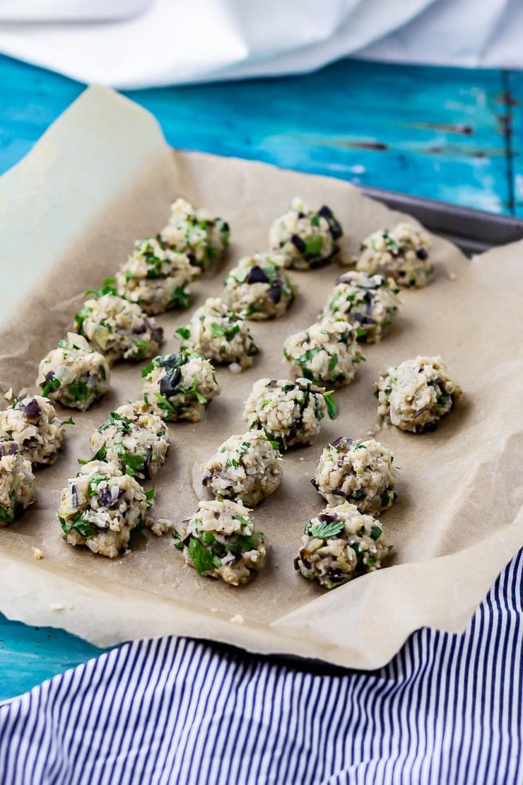 Vegetarian meatballs on a tray before cooking on a blue background with a striped cloth