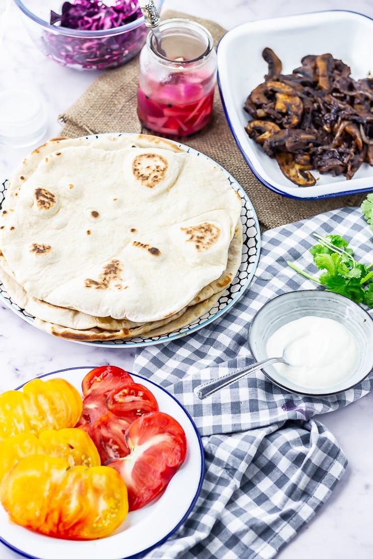 Ingredients for mushroom wraps on a marble background with a checked cloth