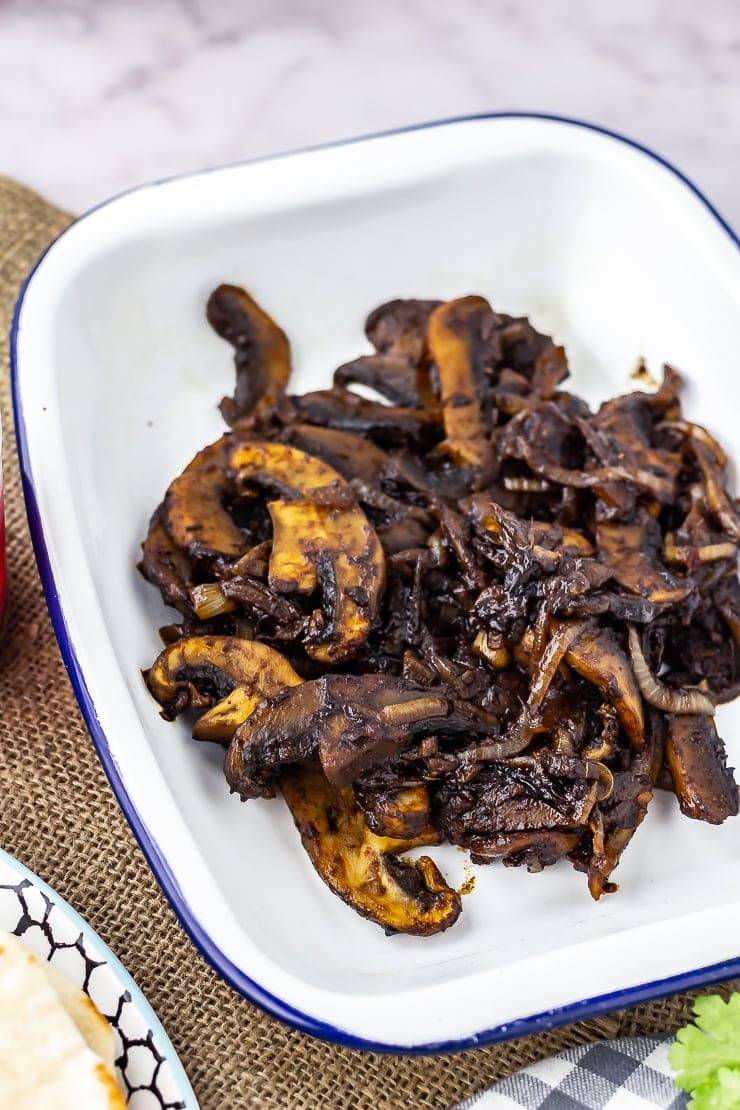 Mushrooms for mushroom wraps in a white dish on a hessian background