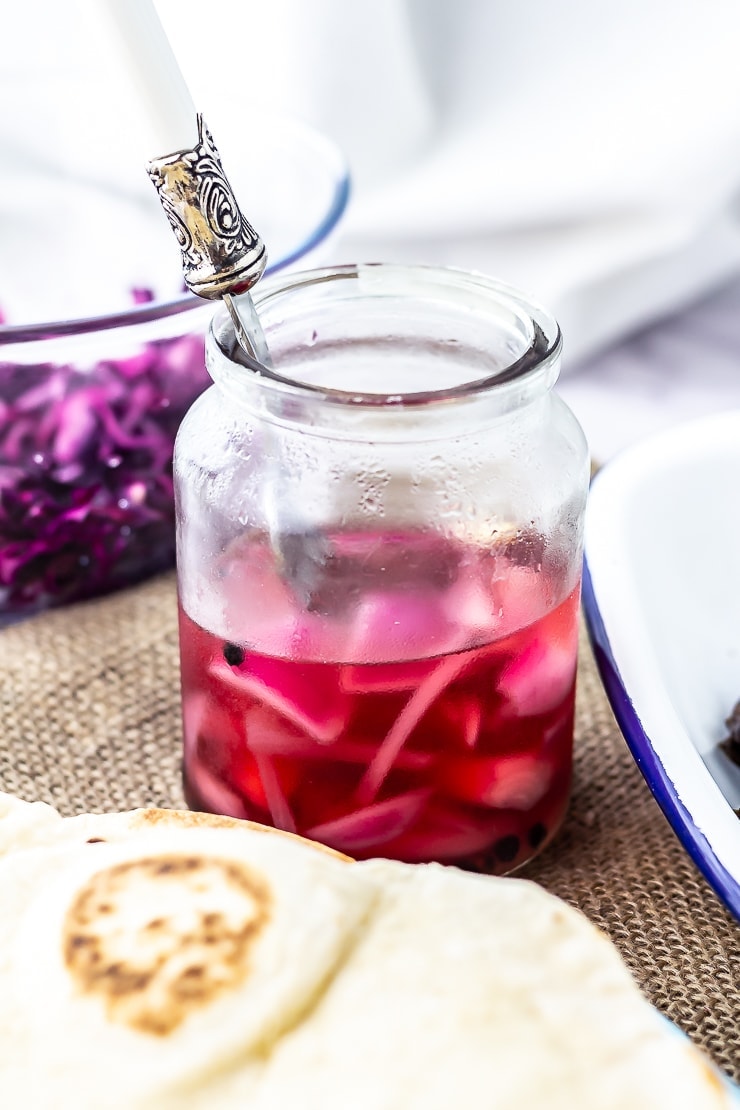 Pickled red onions for mushroom wraps in a jar on a hessian background