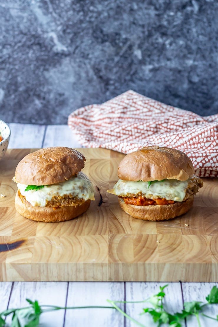 Veggie burgers with quinoa on a wooden board over a white wooden background