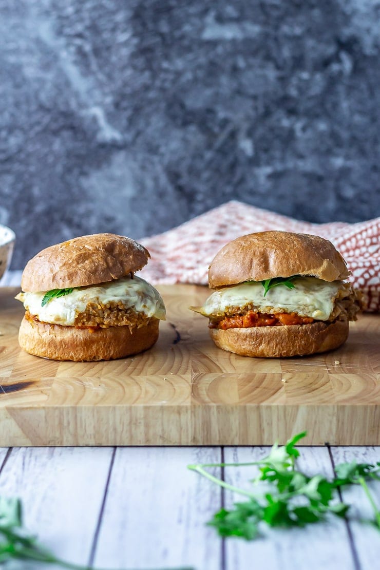 Two veggie burgers on a wooden board over a white wooden background