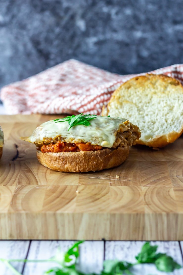 Side on shot of veggie burger on a wooden board over a white wooden background