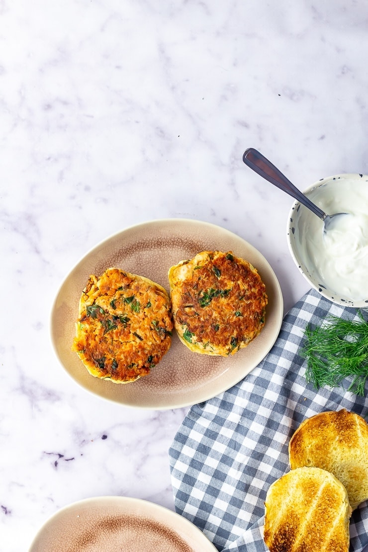 Overhead shot of salmon burgers with a checked cloth over a marble background