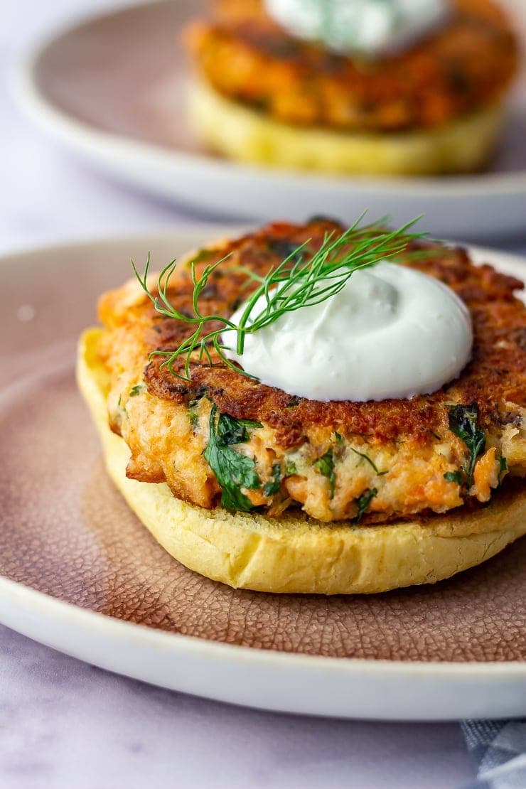 Side shot of salmon burgers with garlic yoghurt and dill