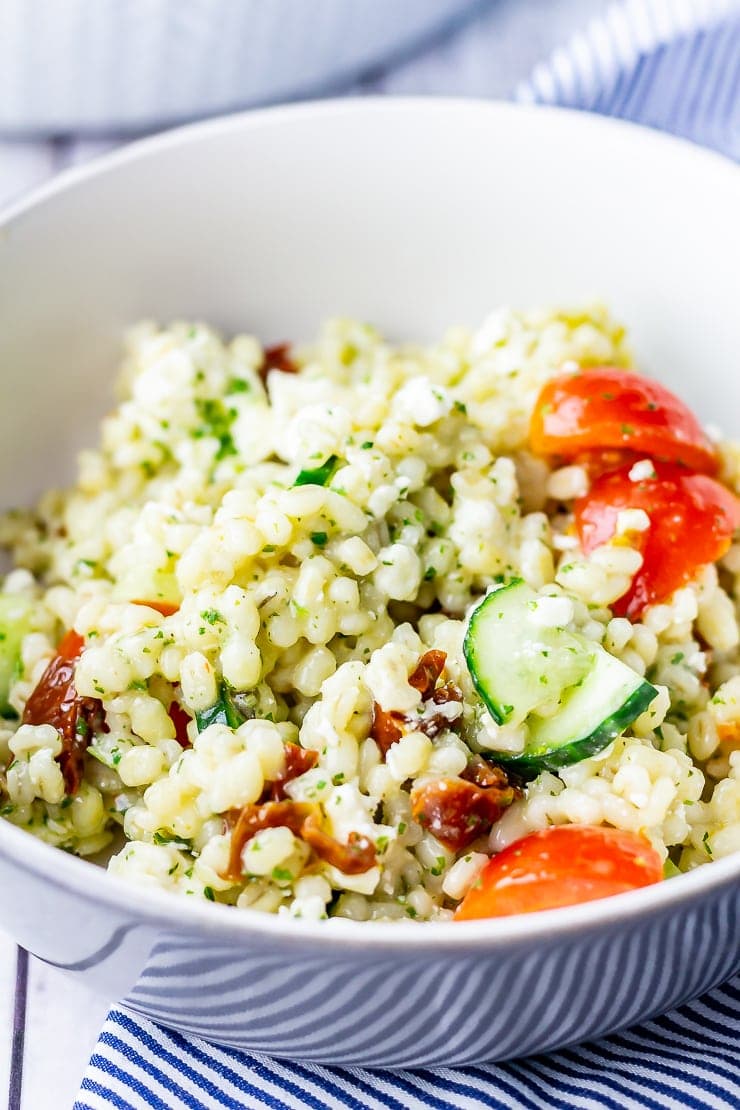 Bowl of summer salad with pearl barley on a striped cloth