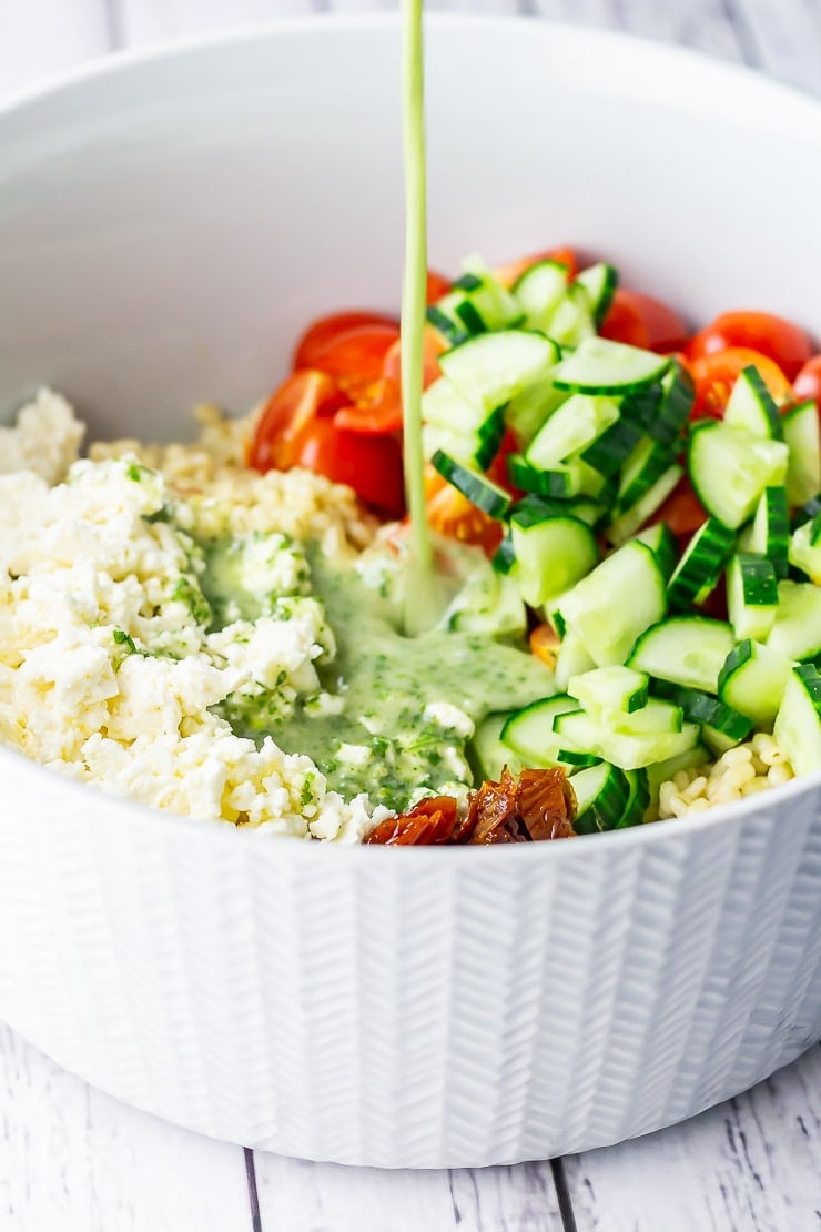 Dressing pouring on to summer salad in a large bowl