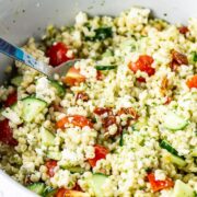 Summer salad with pearl barley in a bowl with a spoon