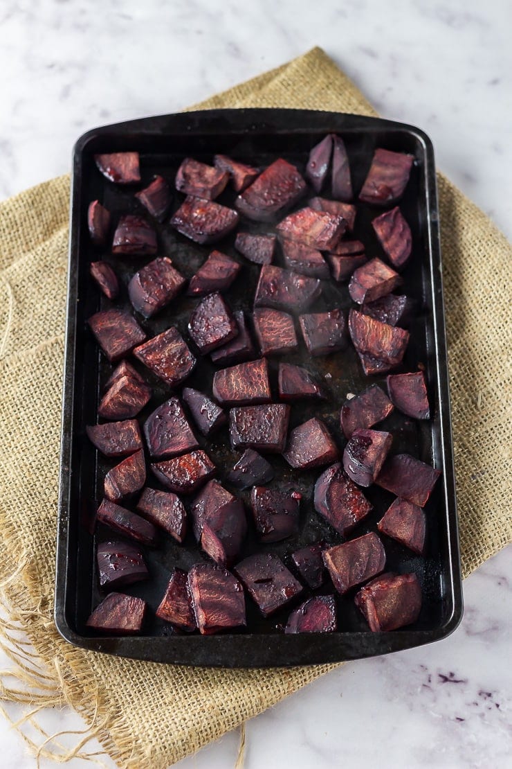 Roasted beetroot on a baking sheet over a hessian mat