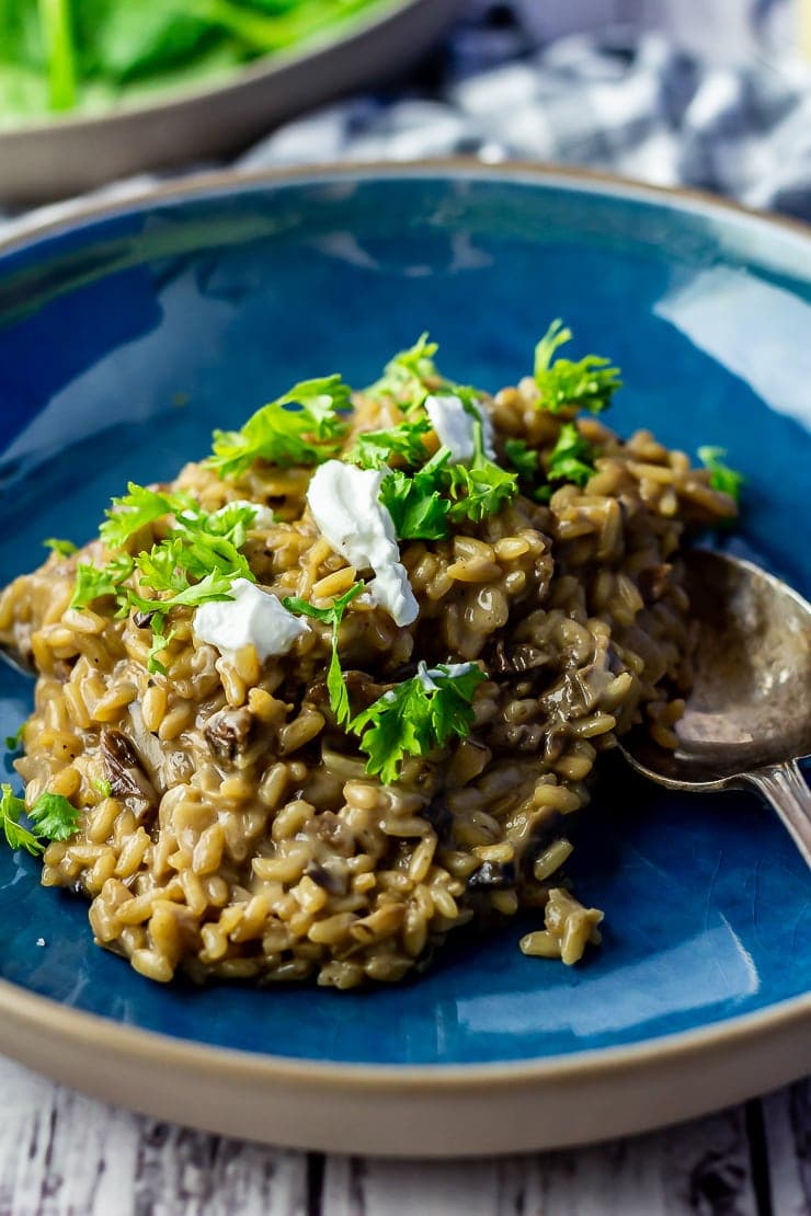 Close up of black garlic risotto in a blue bowl 