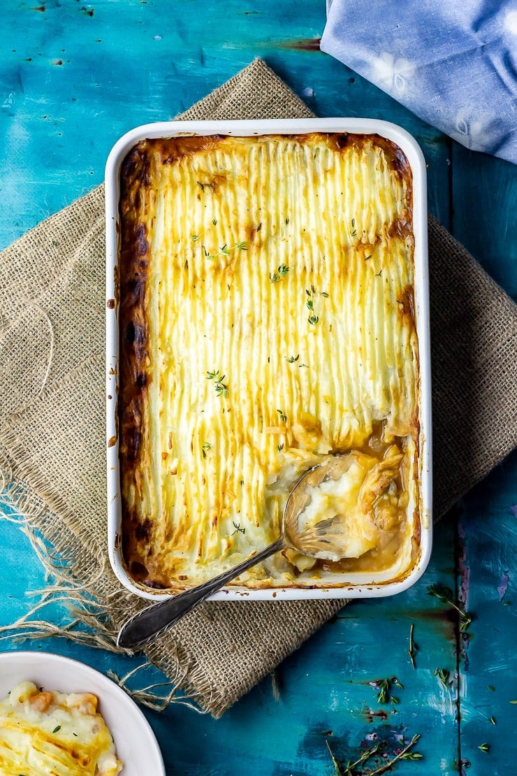 Overhead shot of vegetarian shepherd's pie on a hessian mat over a blue background