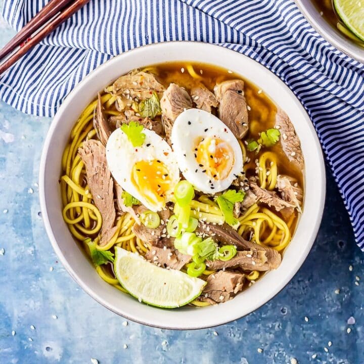 Overhead shot of leftover turkey soup with noodles on a blue background