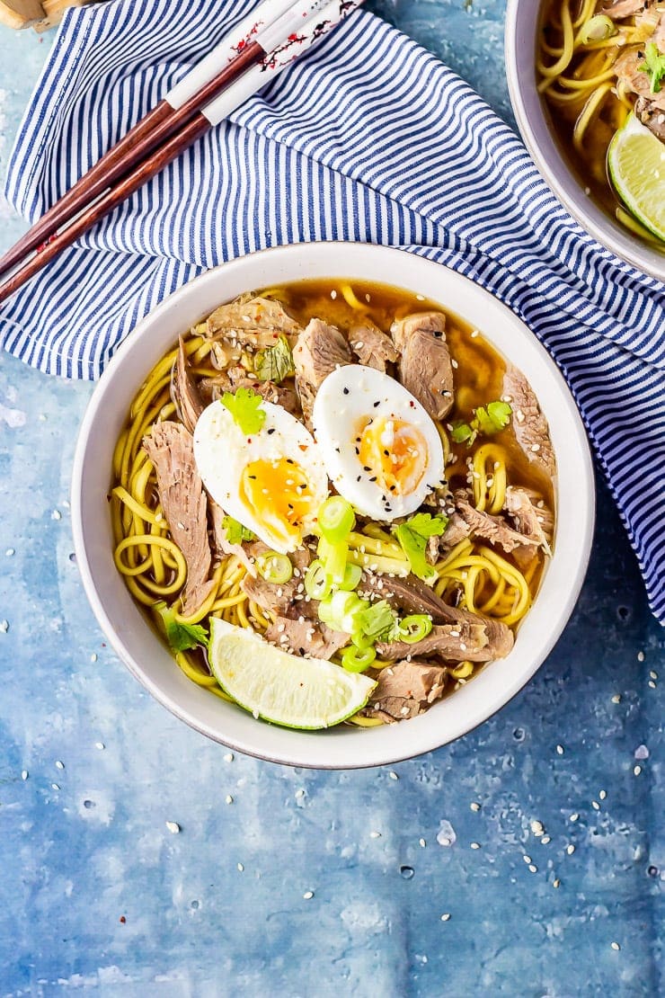 Overhead shot of leftover turkey soup with noodles on a blue background