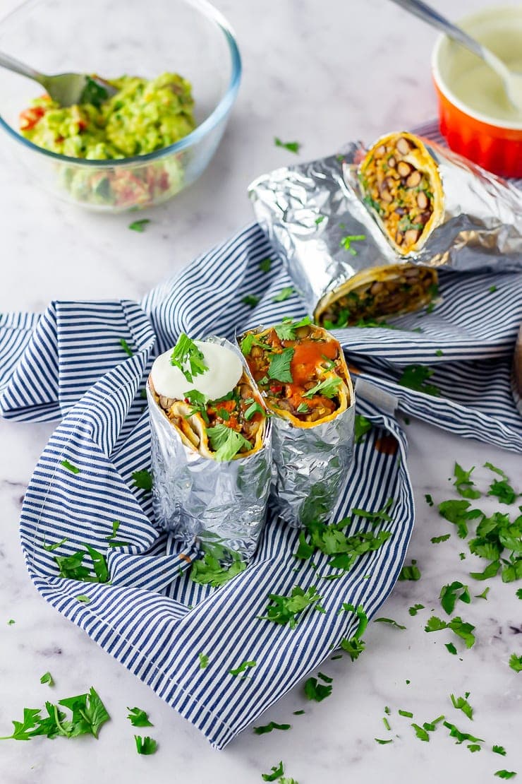 Vegetarian breakfast burrito on a striped cloth over a marble background