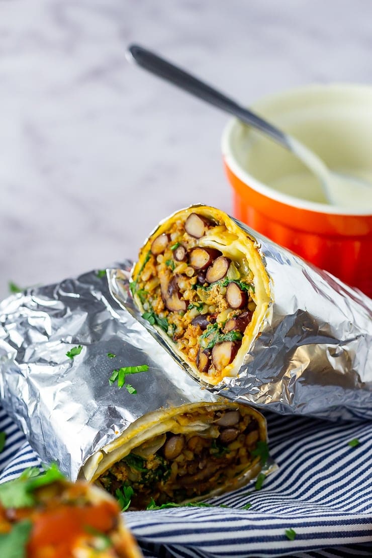 Vegetarian breakfast burrito in foil on a striped cloth