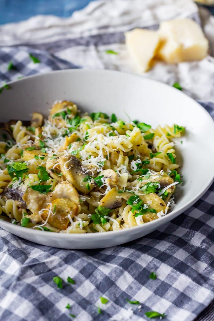 Bowl of garlic mushroom pasta on a checked cloth