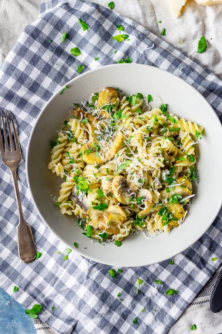 Overhead shot of mushroom pasta on a checked cloth