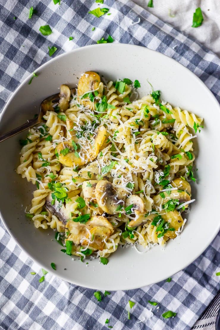 Overhead shot of mushroom pasta on a checked cloth