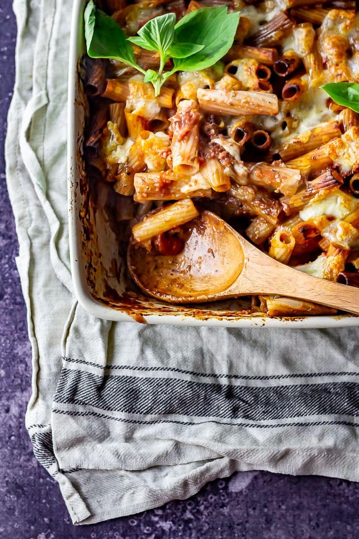 Overhead shot of one pot cheese and tomato pasta bake with a wooden spoon