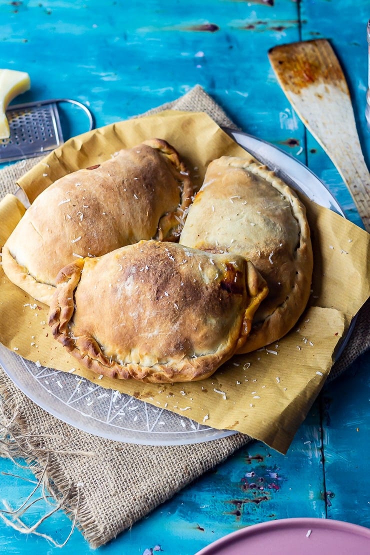 Roasted vegetable calzones on paper over a plate