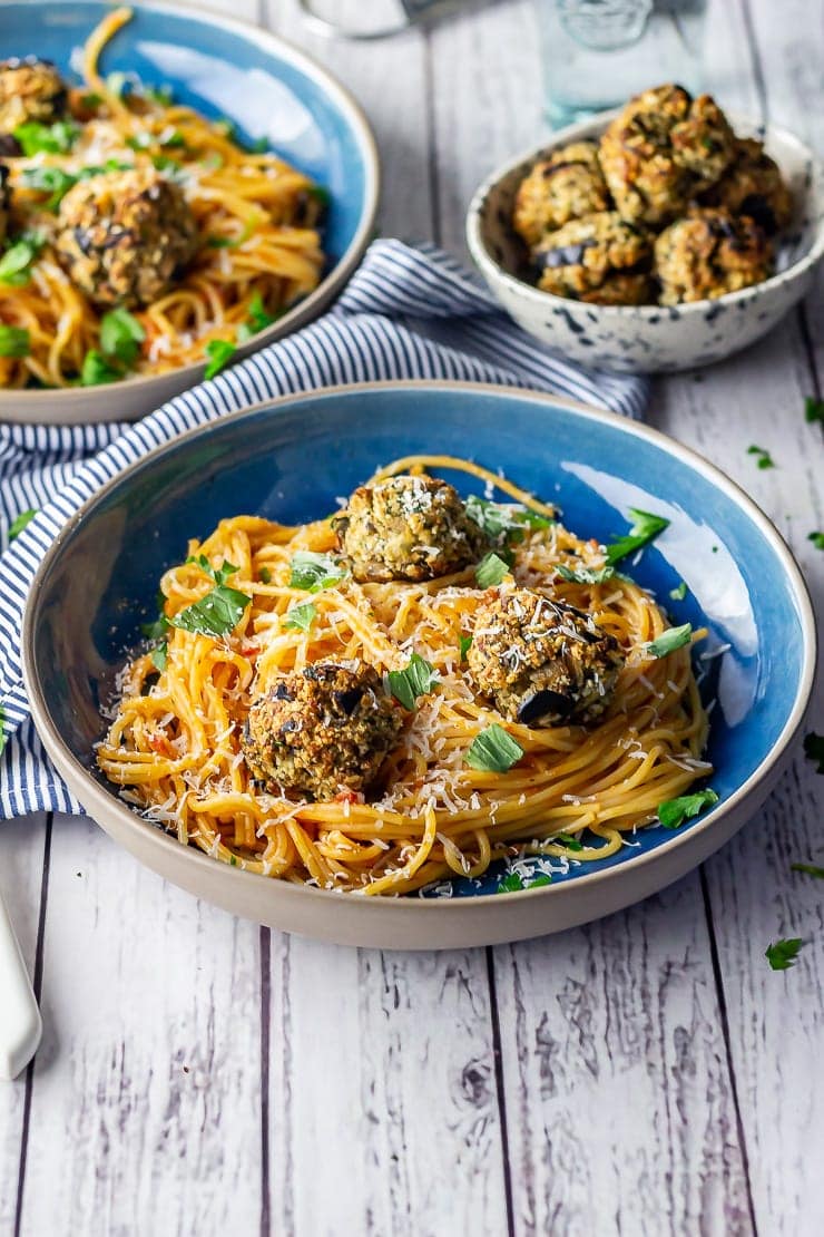Vegetarian spaghetti and meatballs in a blue bowl on a white wooden background