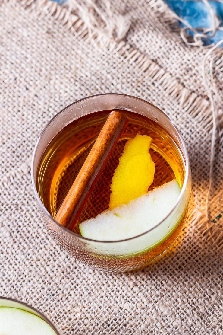 Overhead shot of spiced apple cocktail with rum on a mat