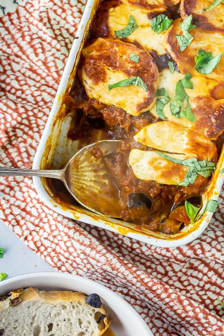 Overhead shot of halloumi bake with a spoonful taken on a patterned cloth